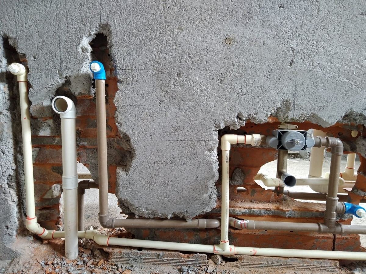 Pontos de água e esgoto montados em parede de obra pela J&C Elétrica, com registro de gaveta e tubulação embutida no rasgo.